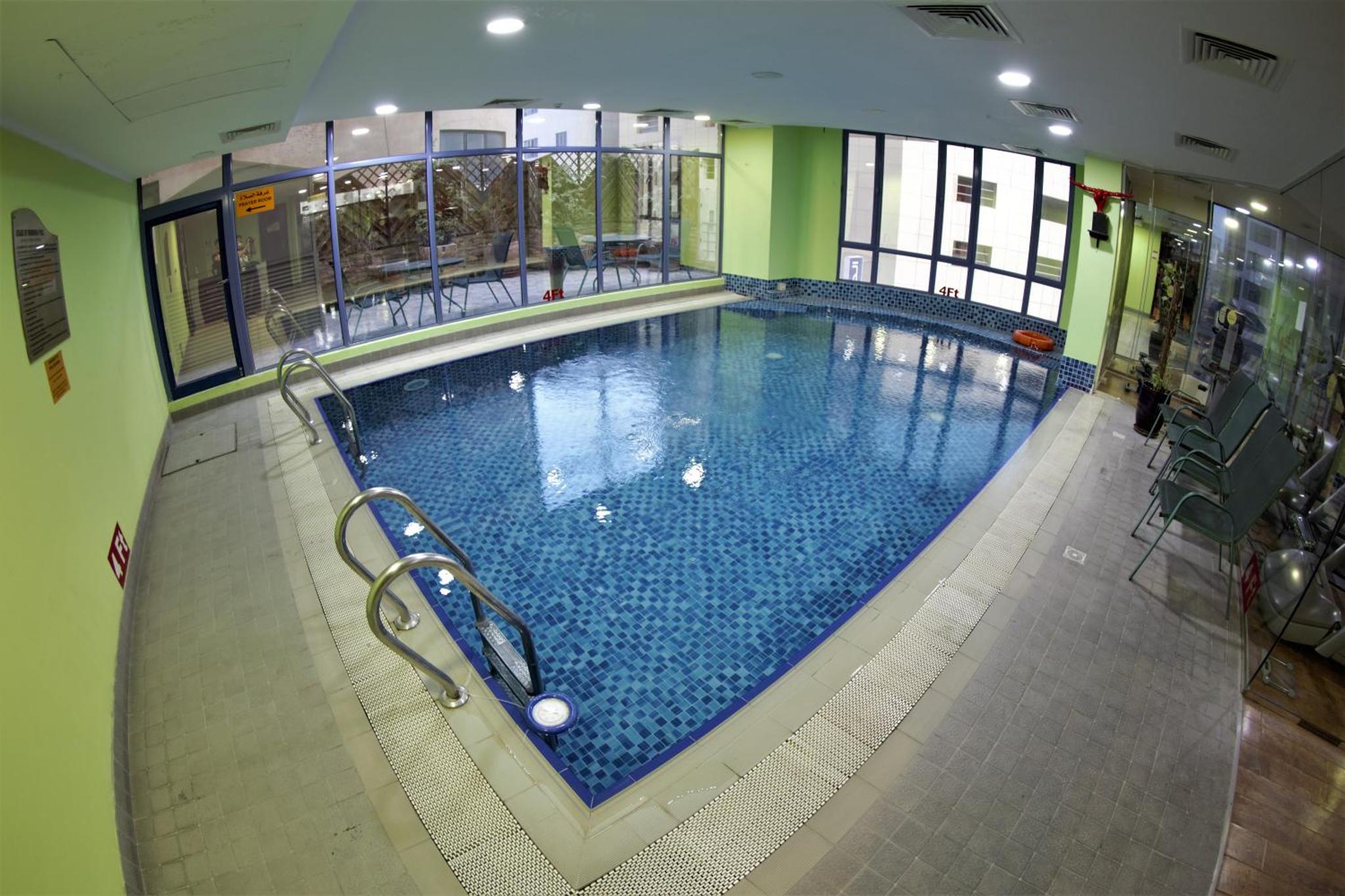 an overhead view of a swimming pool in a building at Grand Safir Hotel in Manama +30 photos