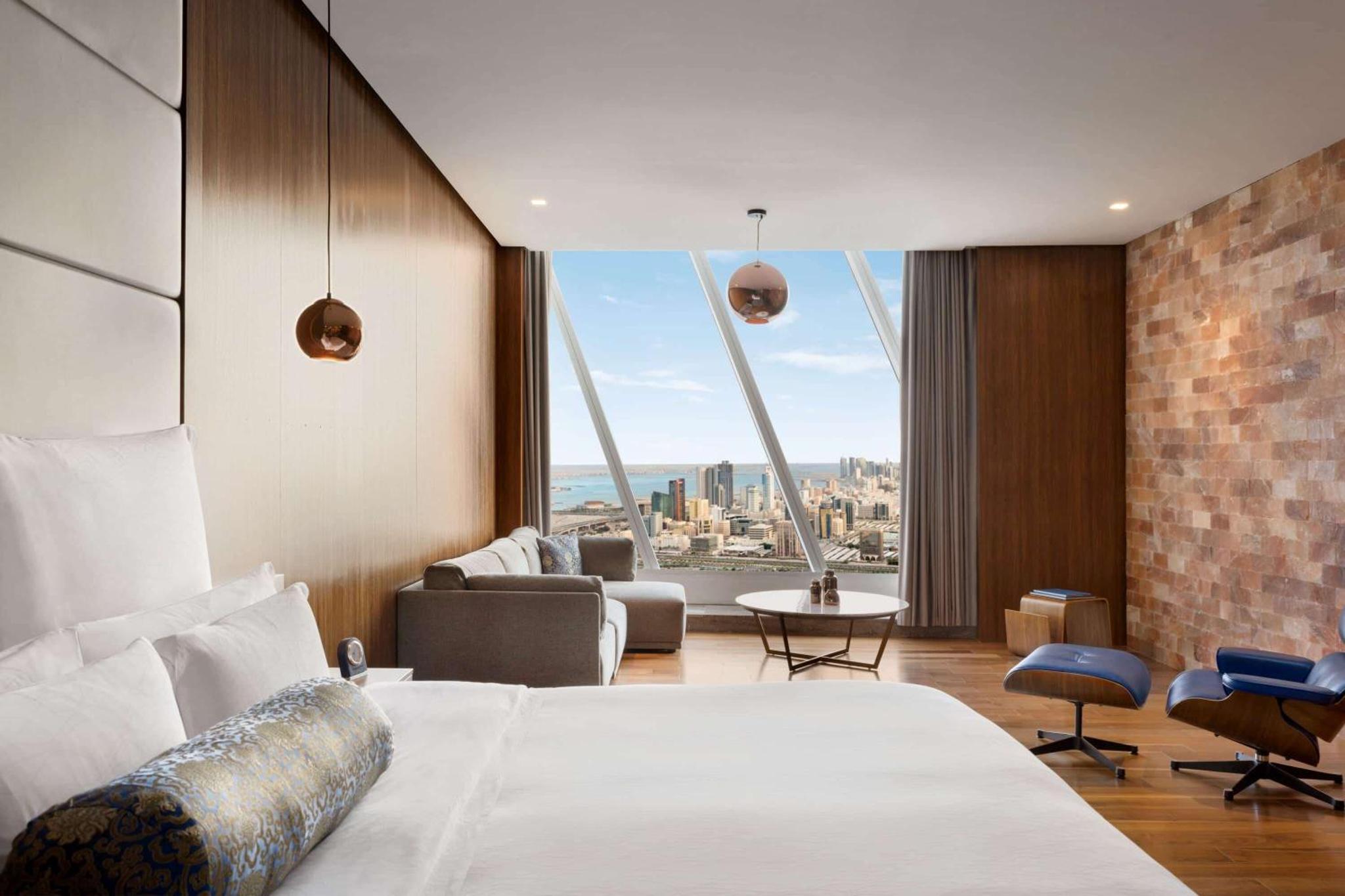 a bedroom with a bed and a view of the city at Wyndham Grand Manama in Manama +89 photos