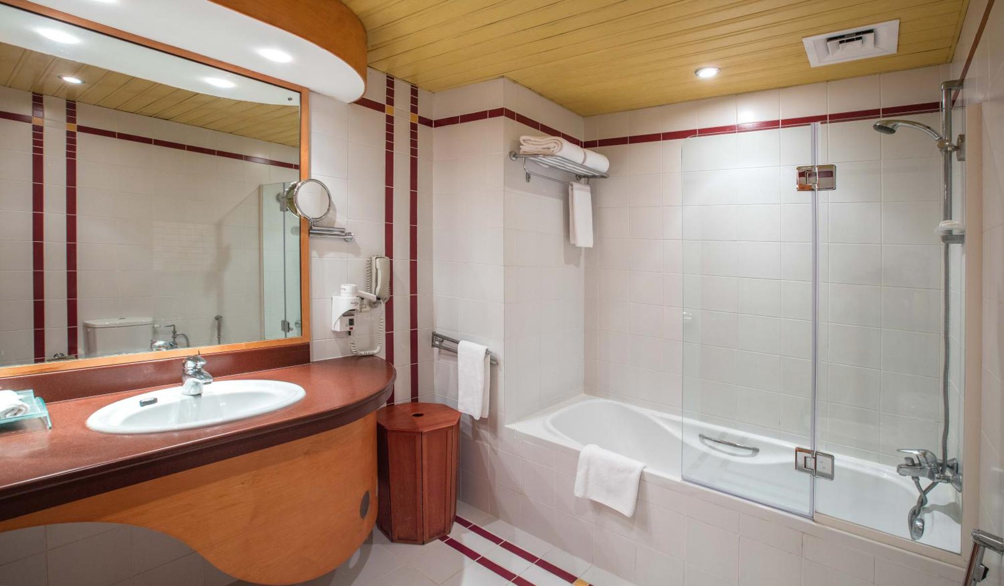a bathroom with a sink and a bath tub at Gulf Court Hotel in Manama +56 photos