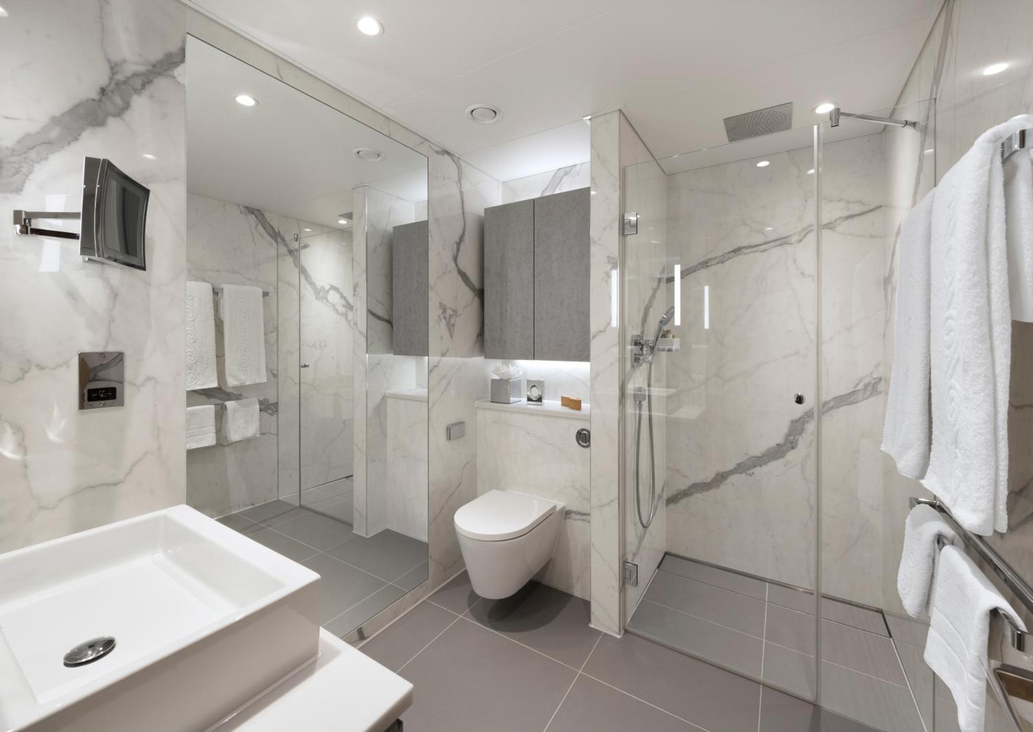 a bathroom with a toilet and a shower and a sink at Tower Suites by Blue Orchid in London