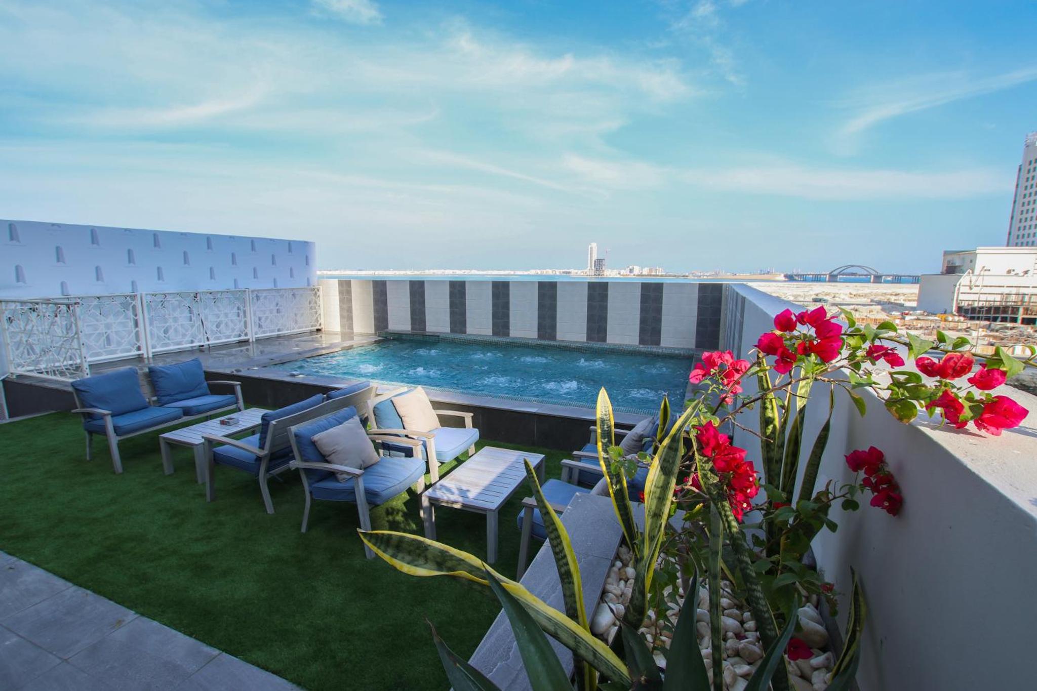 a balcony with a swimming pool on top of a building at The Seven Hotel in Manama