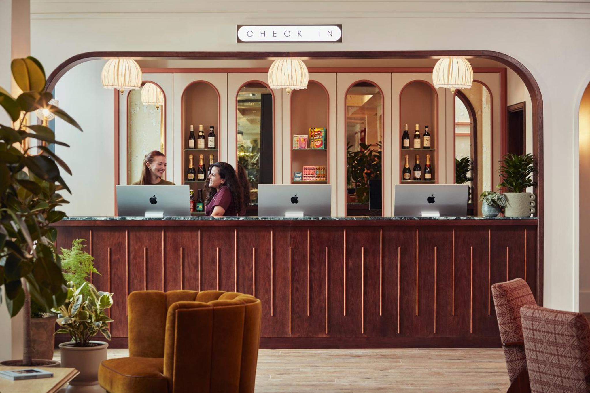 two women sitting at a bar with their laptops at The Hoxton, Shepherds Bush in London