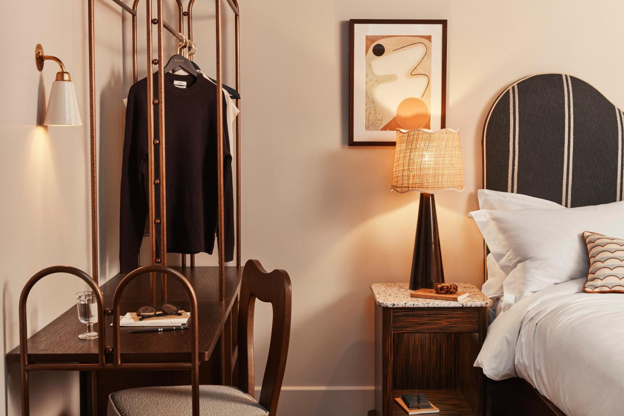 a bedroom with a bed and a desk and a chair at The Hoxton, Shepherds Bush in London +34 photos