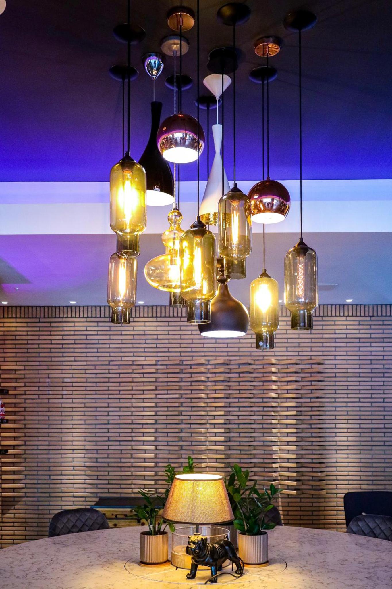 a room with a table with a lamp and chandeliers at Mercure London Bankside in London