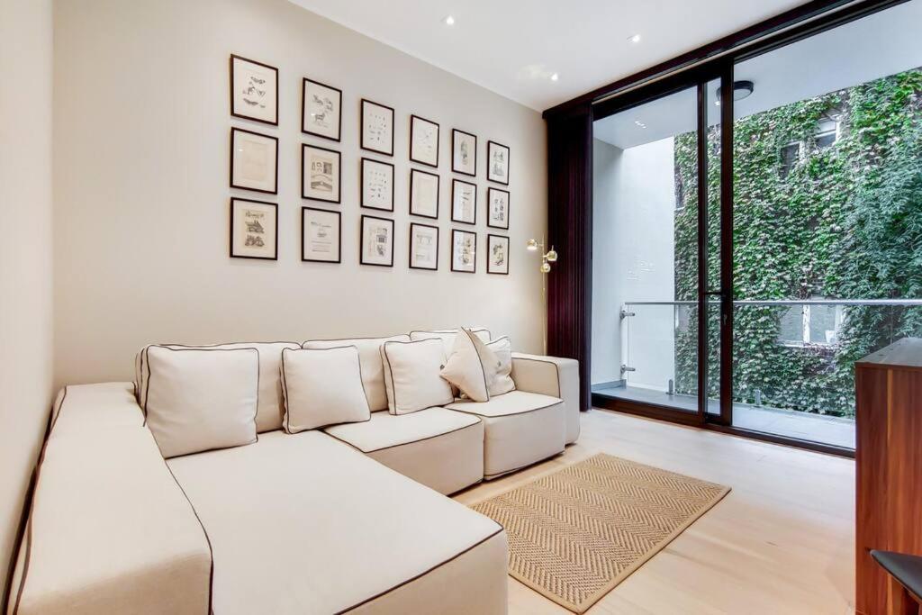 a living room with a white couch and a window at 9 Borough Apartments - Spacious 2-Bed, 2-Bath Steps from London Bridge in London