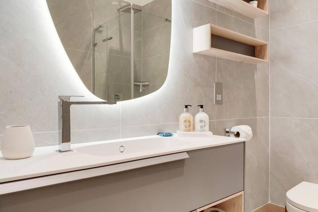 a bathroom with a sink and a mirror at 9 Borough Apartments - Spacious 2-Bed, 2-Bath Steps from London Bridge in London +18 photos