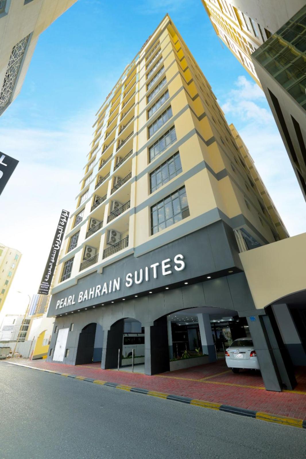 a tall building with a sign that reads san bantam suites at Pearl Bahrain Suites in Manama