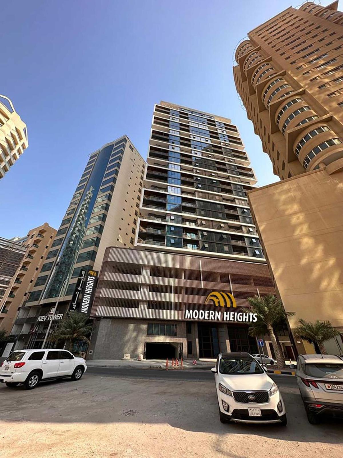 a large building with a morgan hotels sign in front of it at Modern Heights in Juffair