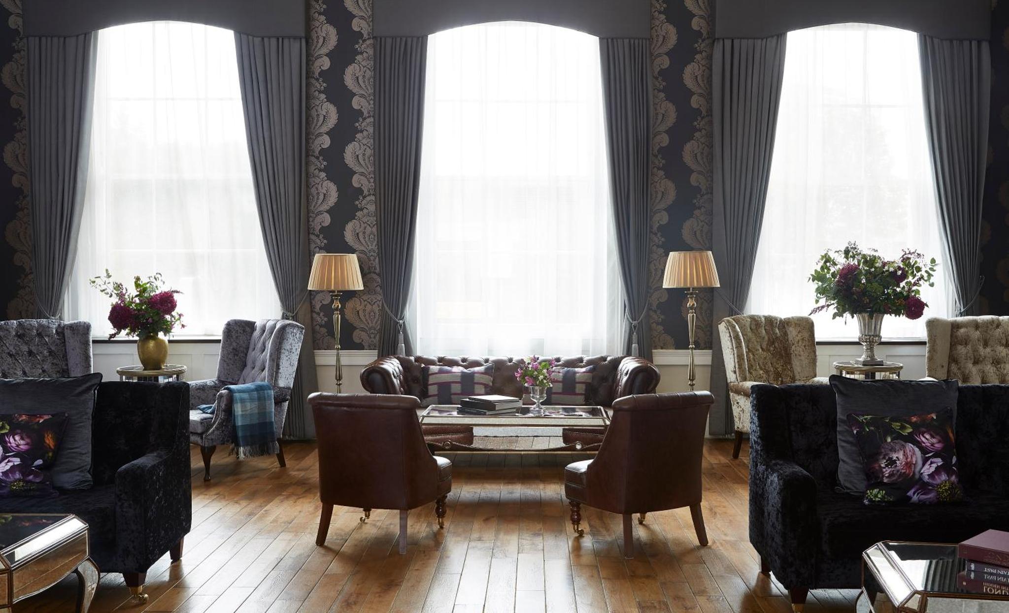 a living room with couches and a table and chairs at The Westbridge Hotel Stratford in London