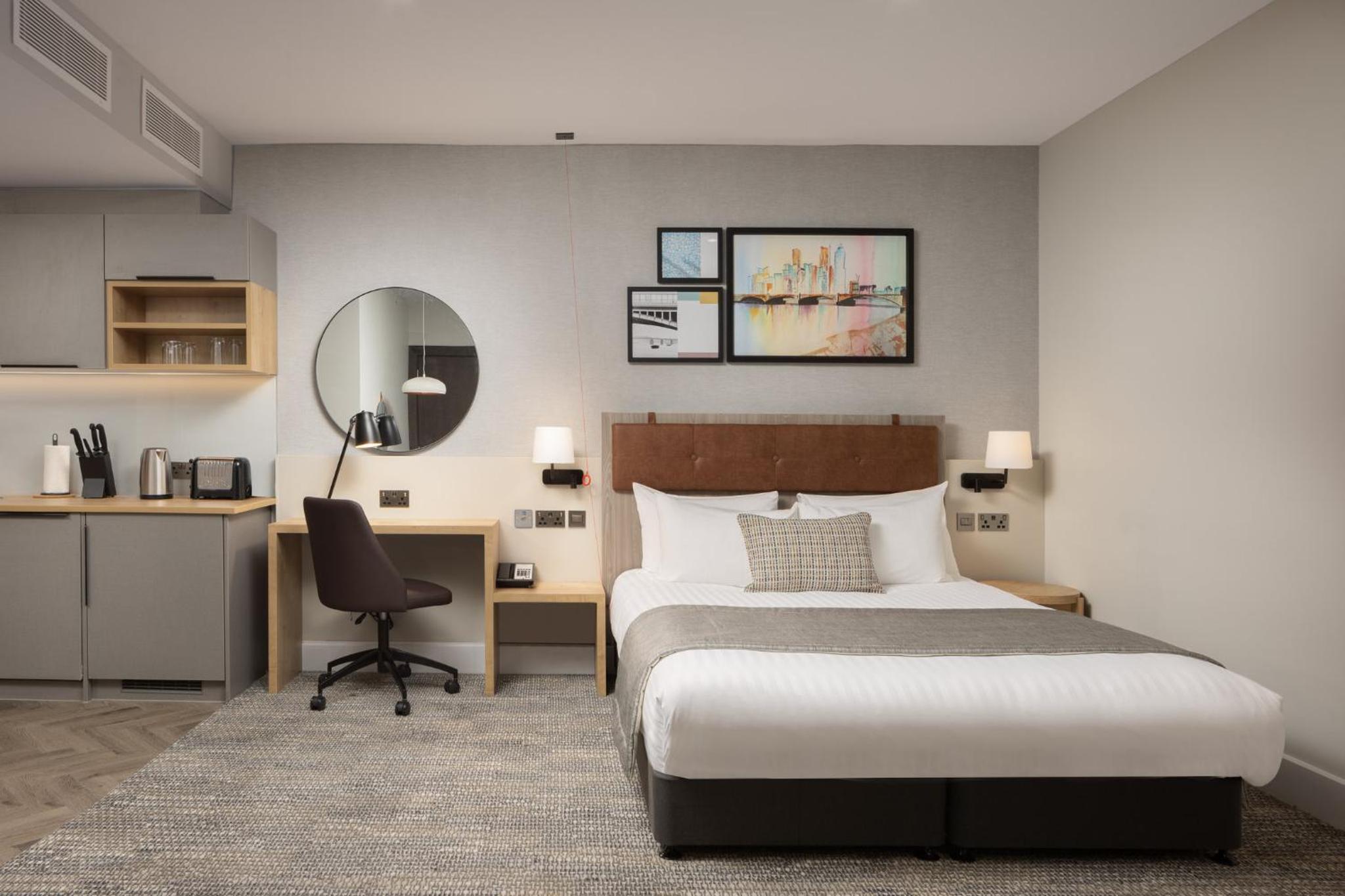 a bedroom with a bed and a desk and a chair at Staybridge Suites London-Vauxhall by IHG in London