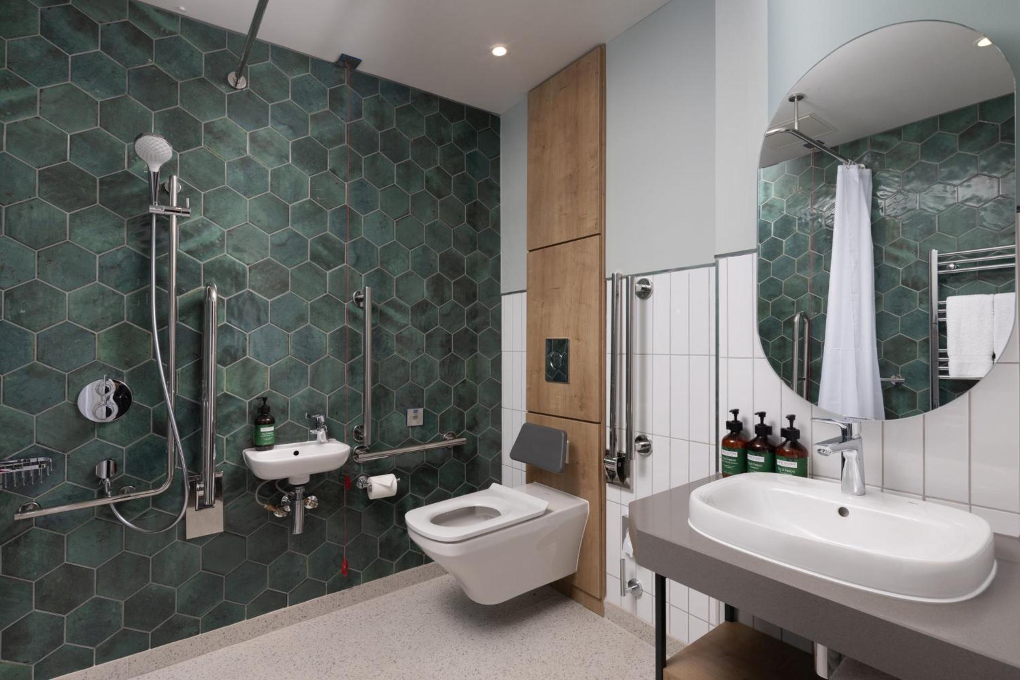 a bathroom with a toilet and a sink and a mirror at Staybridge Suites London-Vauxhall by IHG in London