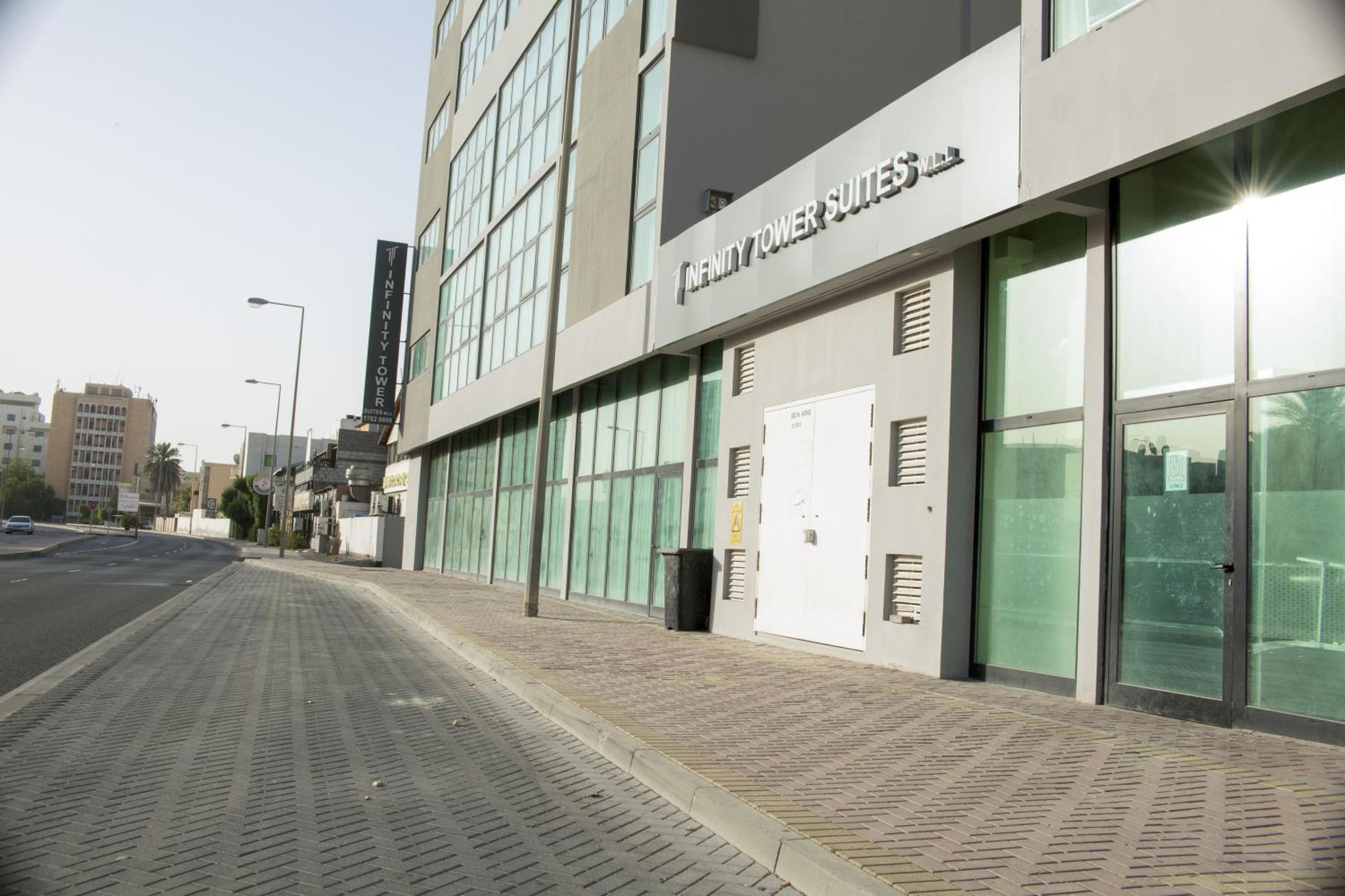 an empty street in front of a building at Infinity Tower Suites WLL in Manama