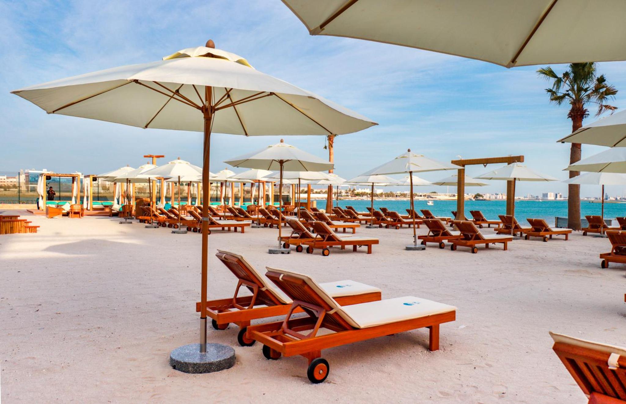 a group of chairs and umbrellas on a beach at Elite Resort & Spa in Manama