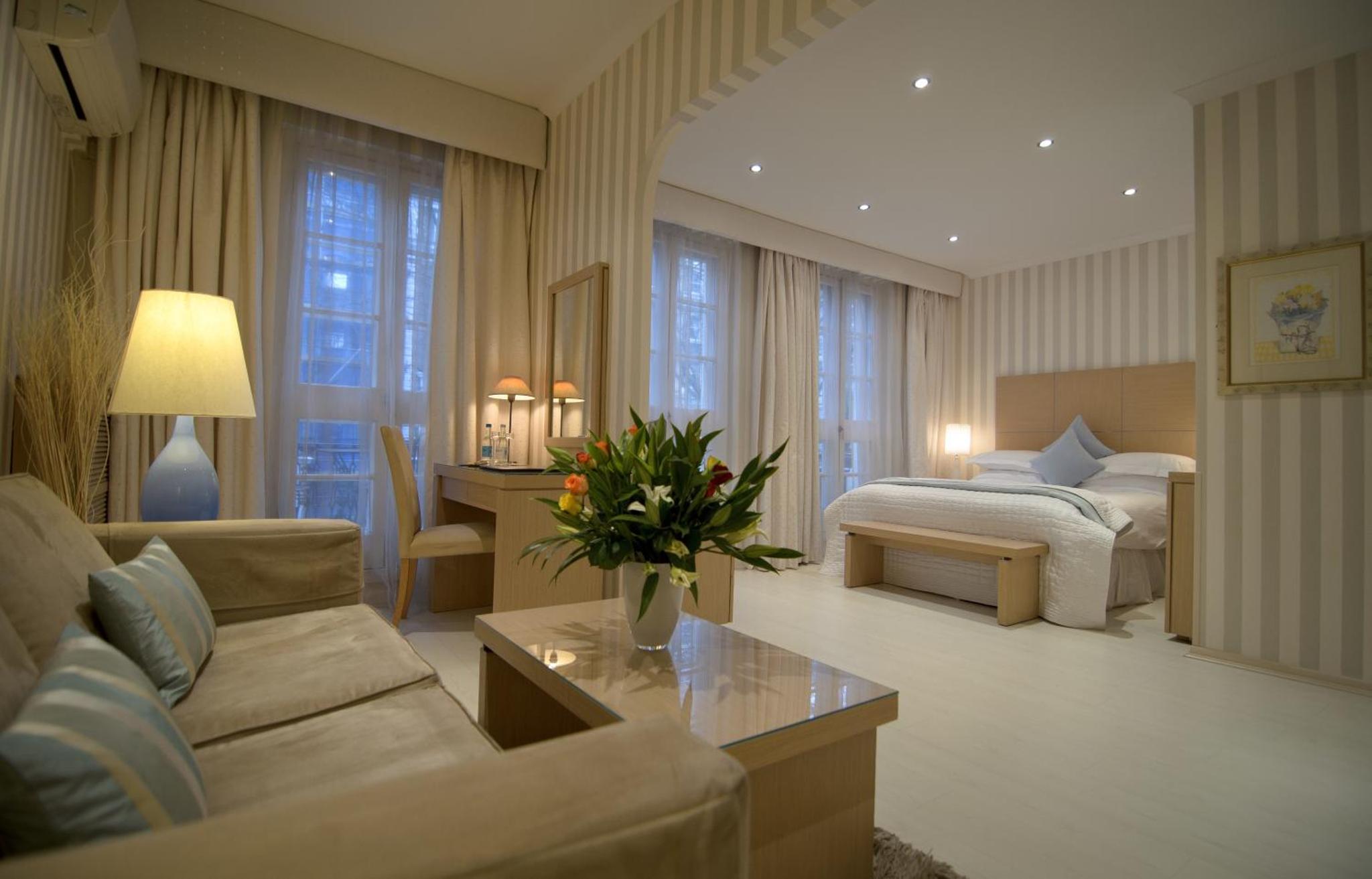 a living room with a couch and a bed at The Beaufort Hotel in London