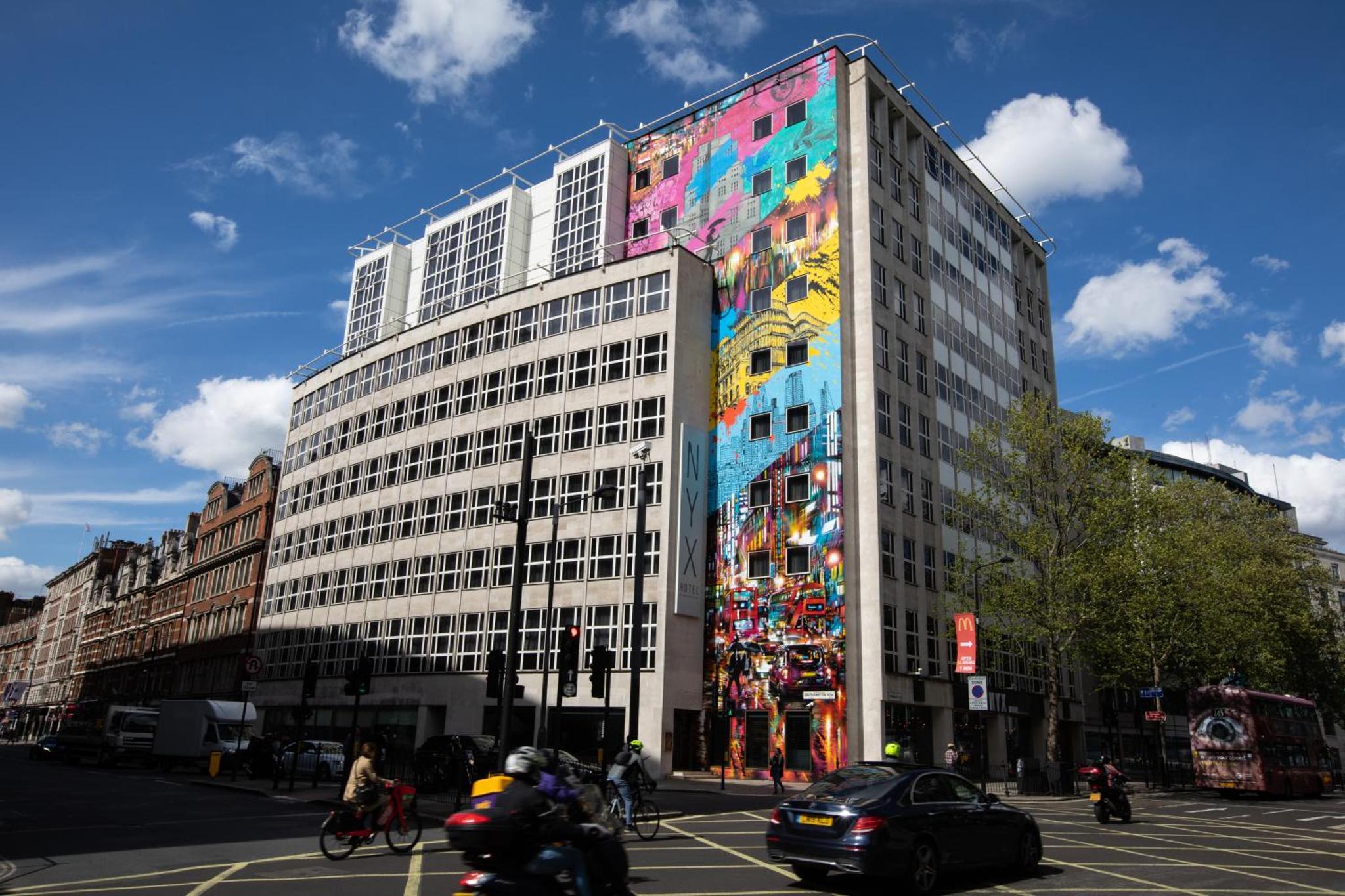 a large building with a painting on the side of it at NYX Hotel London Holborn by Leonardo Hotels in London