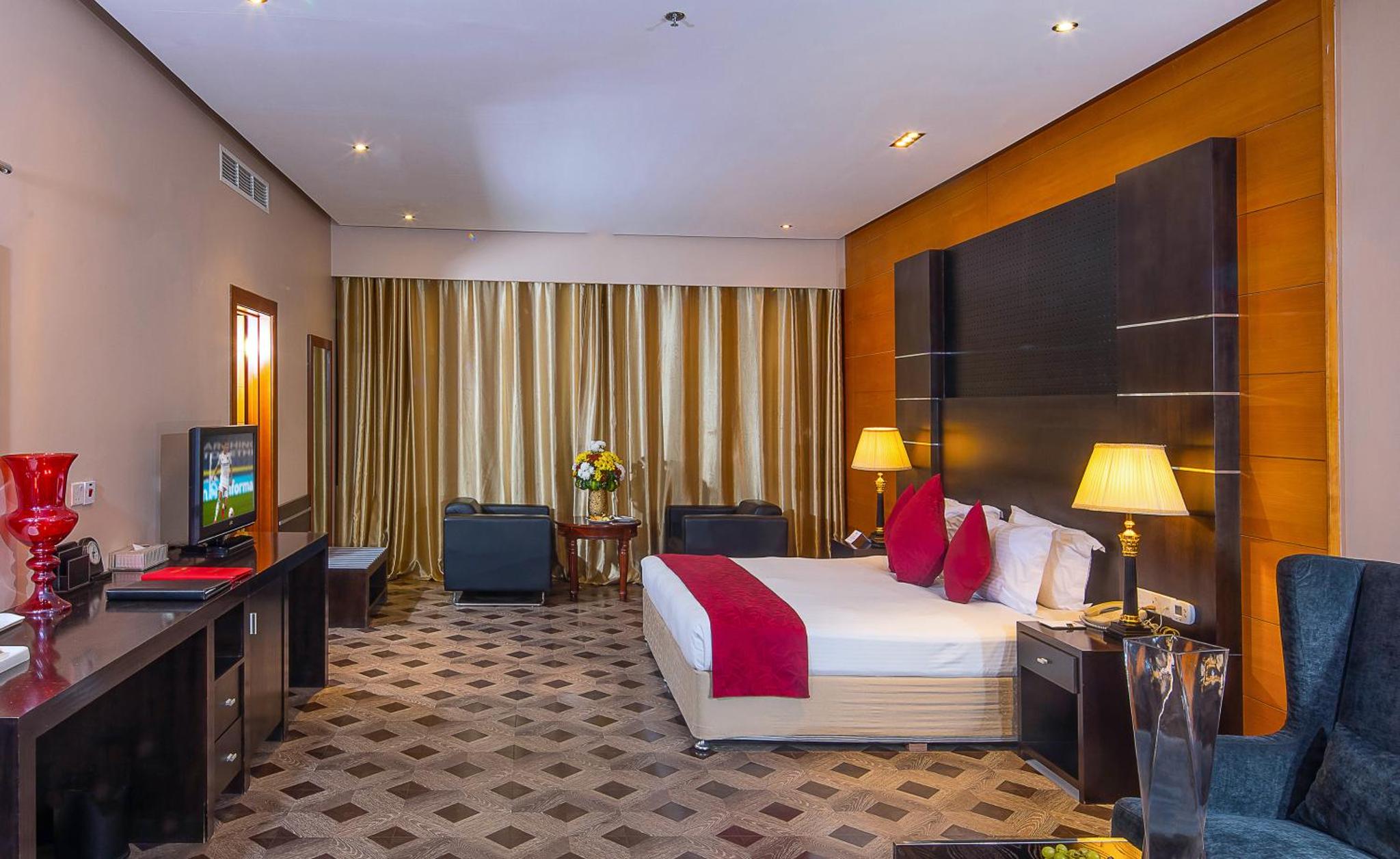 a hotel room with a bed and a television at Diva Hotel in Manama