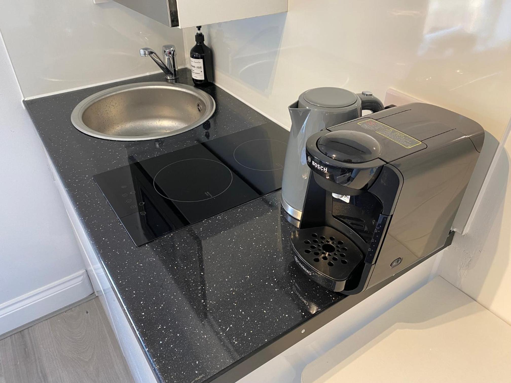 a kitchen counter with a coffee maker and a sink at Stylish Studios by Luxestays Shepherds Bush in London