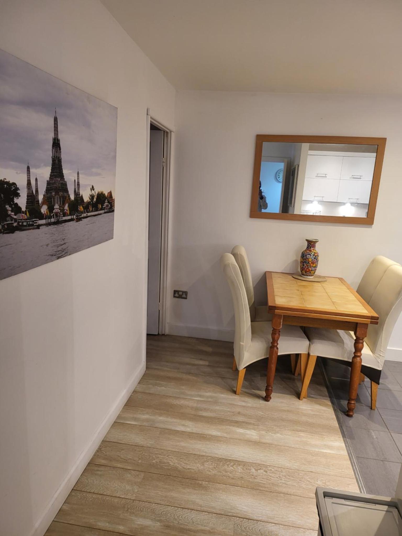 a dining room with a table and chairs and a mirror at WALKING TO TOWER BRIDGE in London +9 photos