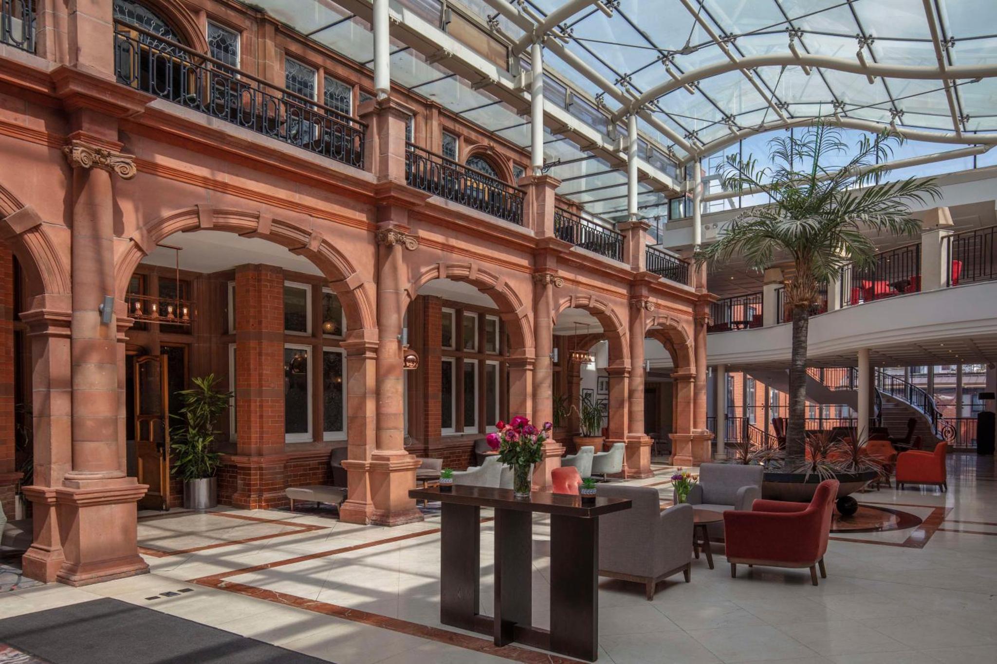 a lobby of a building with a glass ceiling at The Crown London Hotel, Cricklewood North West London, WorldHotels Distinctive in London