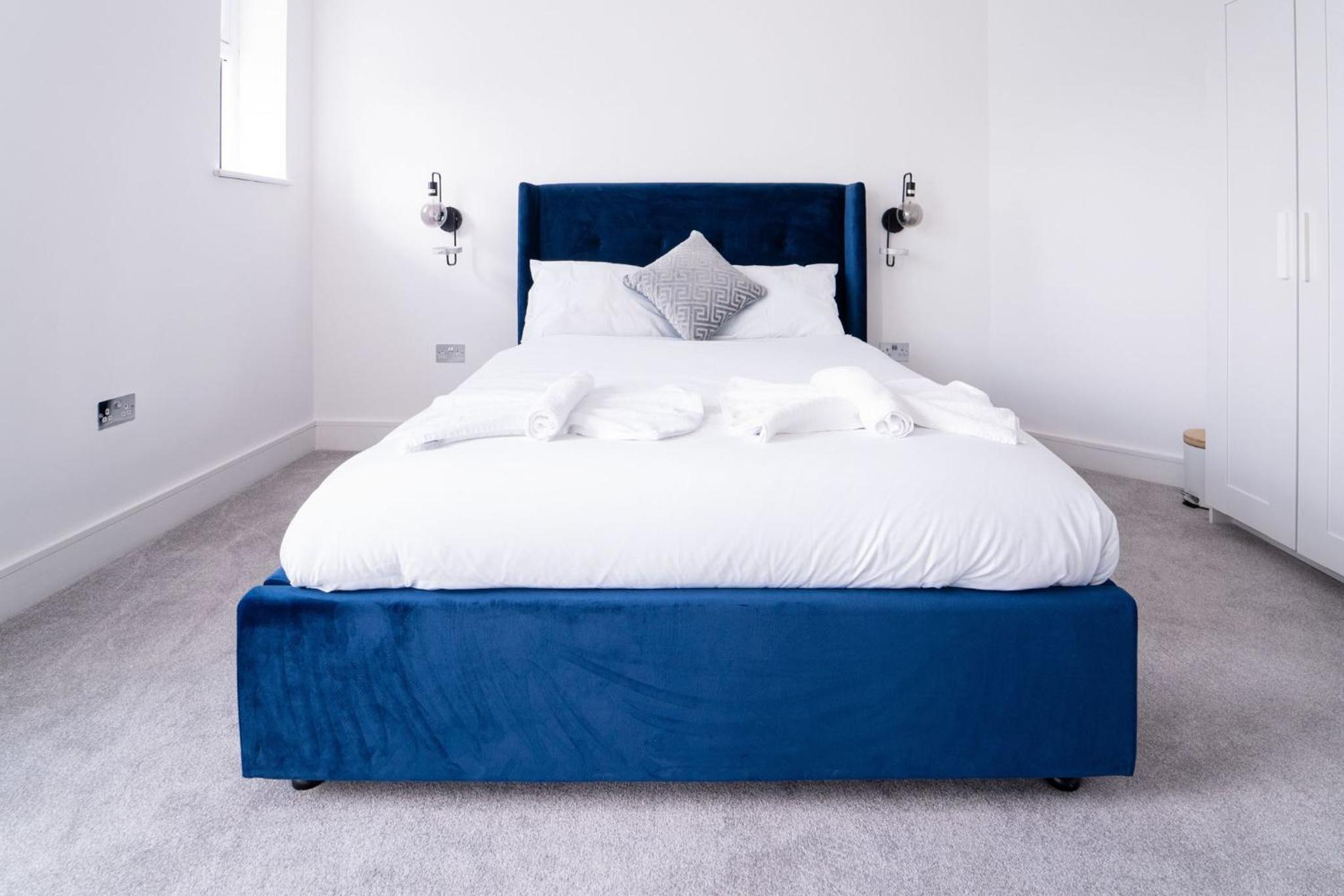 a large blue bed with white sheets and pillows at Woodman Pub in London