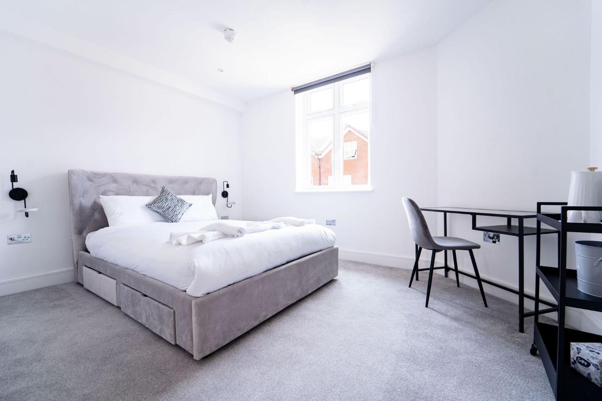 a white bedroom with a bed and a desk at Woodman Pub in London +4 photos