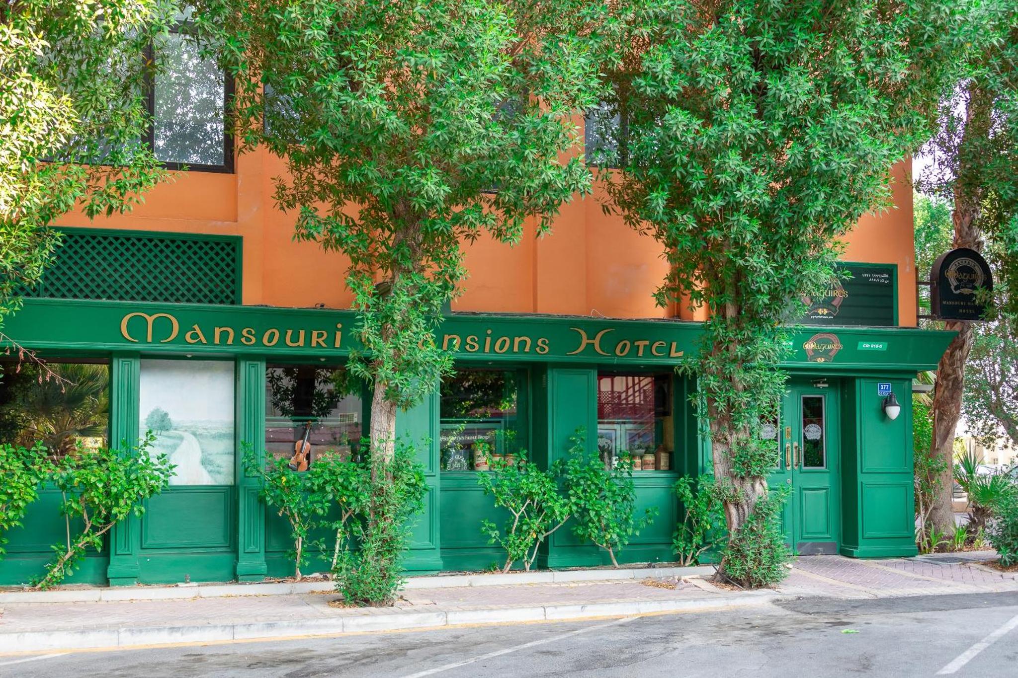 a green storefront of a store on a street at Mansouri Mansions Hotel in Manama