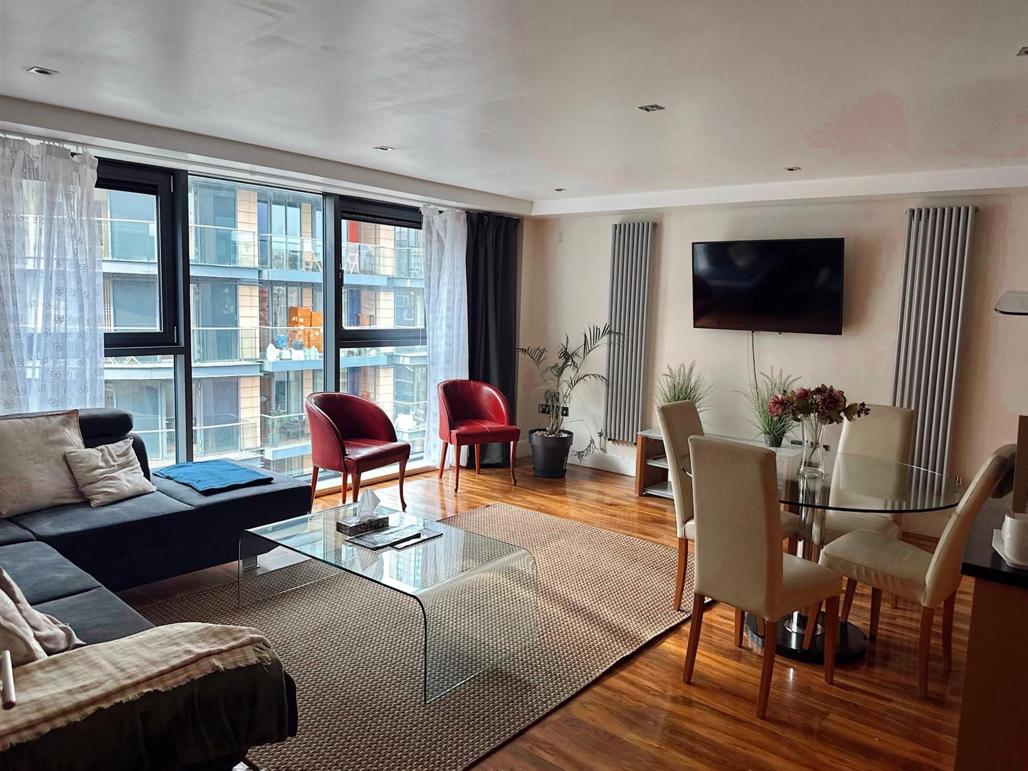 a living room with a couch and a table and chairs at Canary Wharf - Luxury Apartments in London