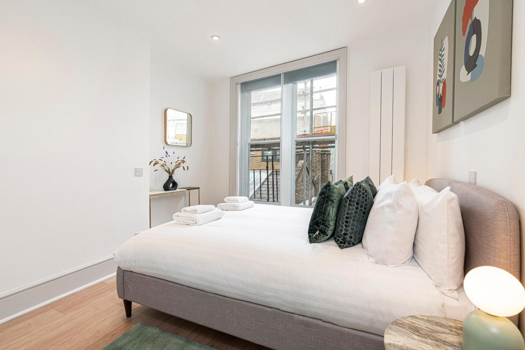 a bedroom with a large bed and a window at Stylish 1 bed flats in Soho, next to Piccadilly Circus and Trafalgar Square in London