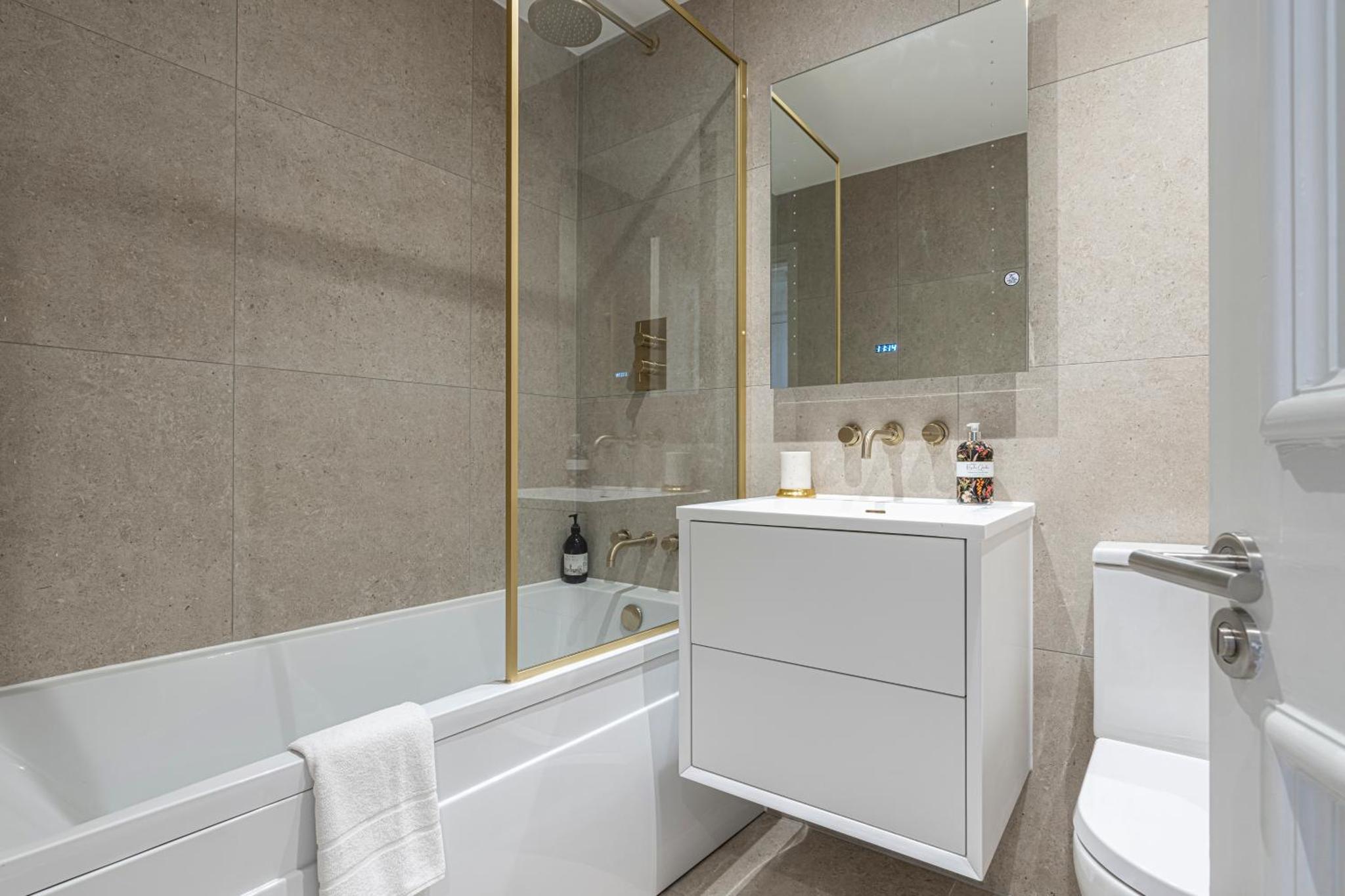 a bathroom with a tub and a toilet and a sink at Stylish 1 bed flats in Soho, next to Piccadilly Circus and Trafalgar Square in London +103 photos