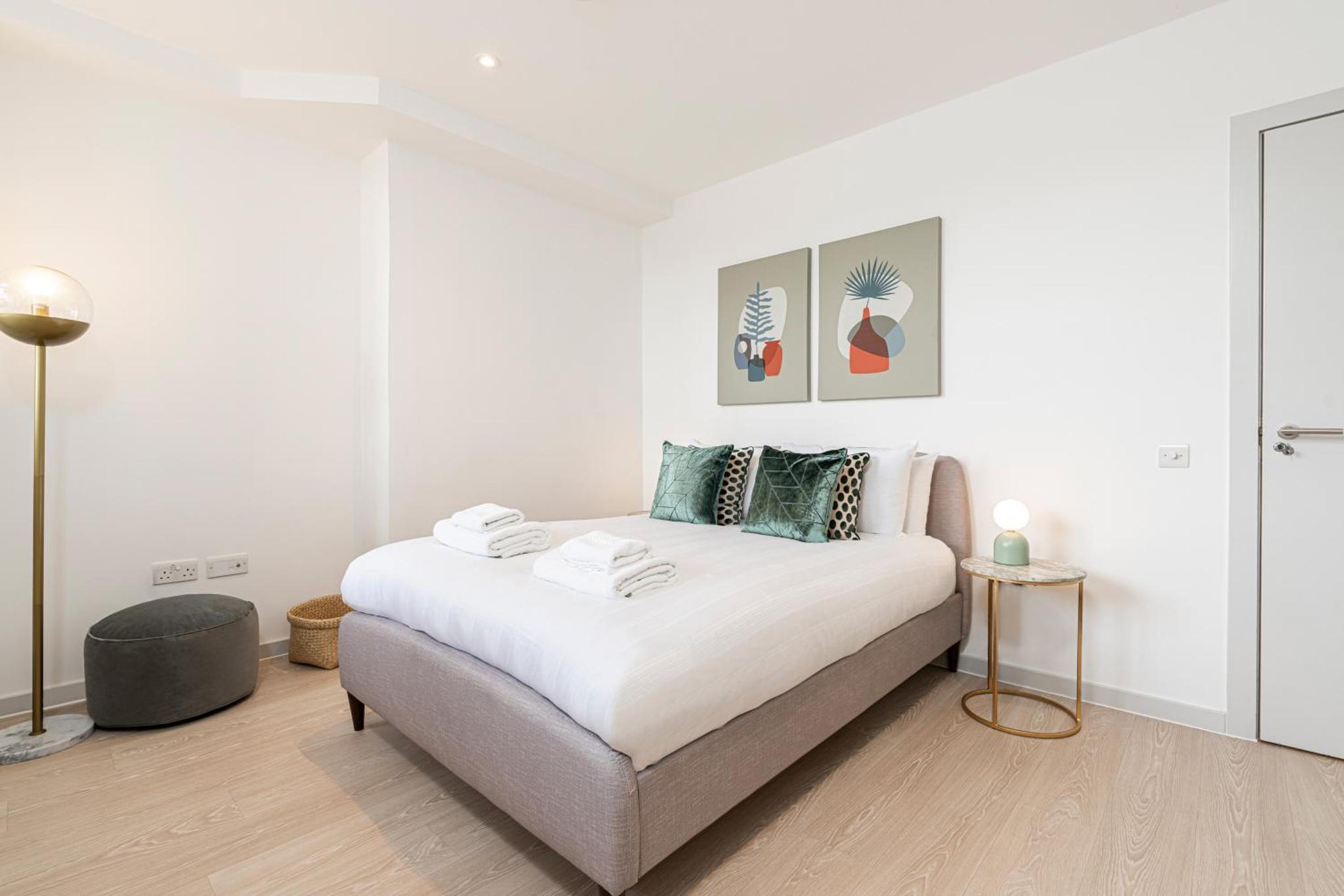 a white bedroom with a bed and a table at Stylish 1 bed flats in Soho, next to Piccadilly Circus and Trafalgar Square in London