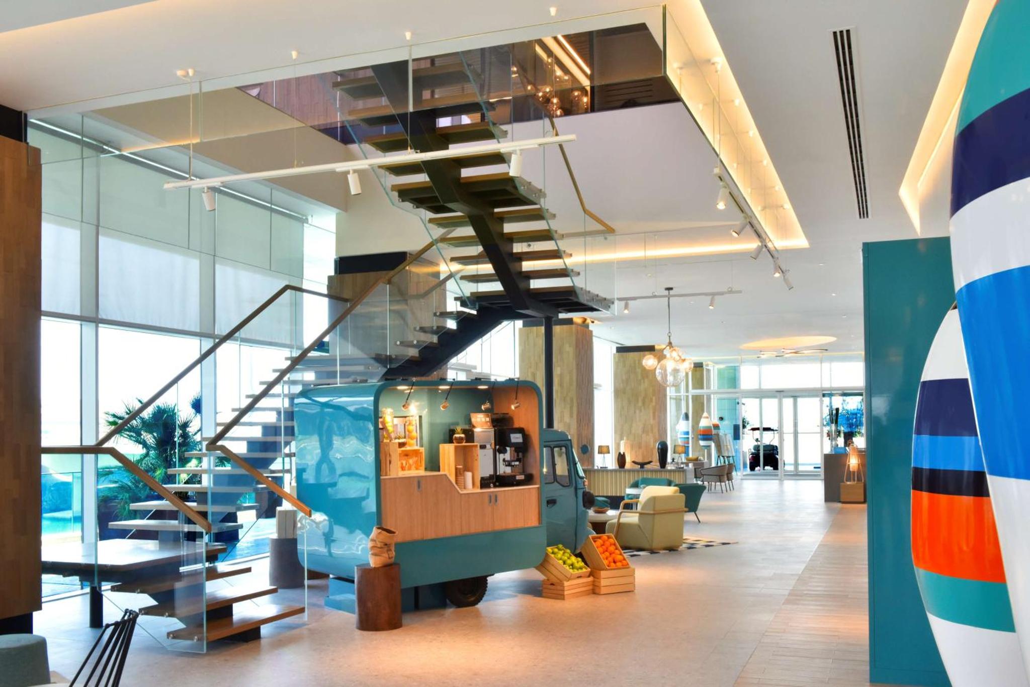 an office lobby with a staircase and a exhibit in the middle at Hilton Garden Inn Bahrain Bay in Manama +49 photos
