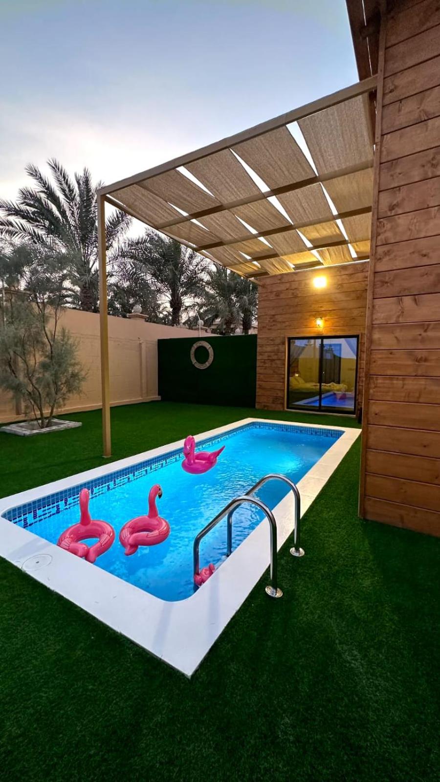 a swimming pool with pink flamingos in a backyard at Cielo Beach Resort in Al Qaryah