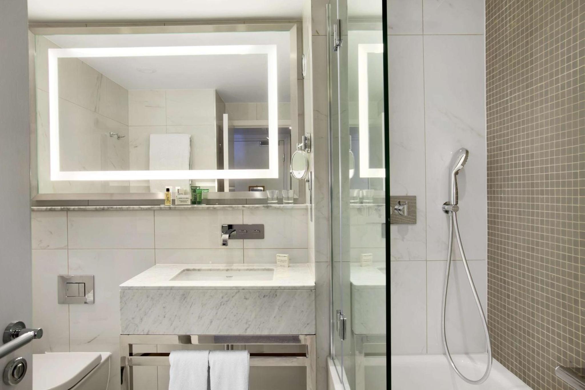 a white bathroom with a sink and a shower at Hilton London Angel Islington in London