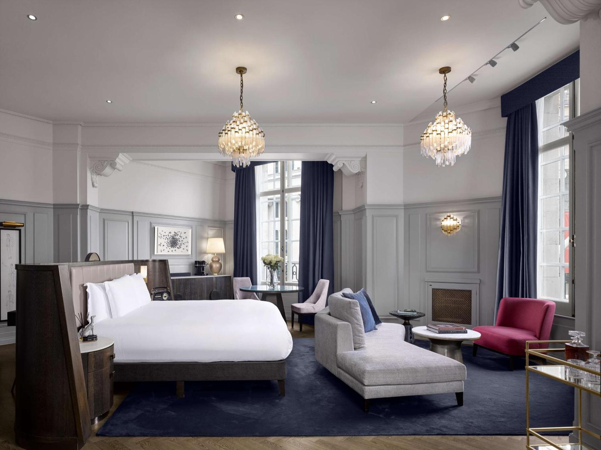 a bedroom with a bed and a living room at The Trafalgar St James London Curio Collection by Hilton in London