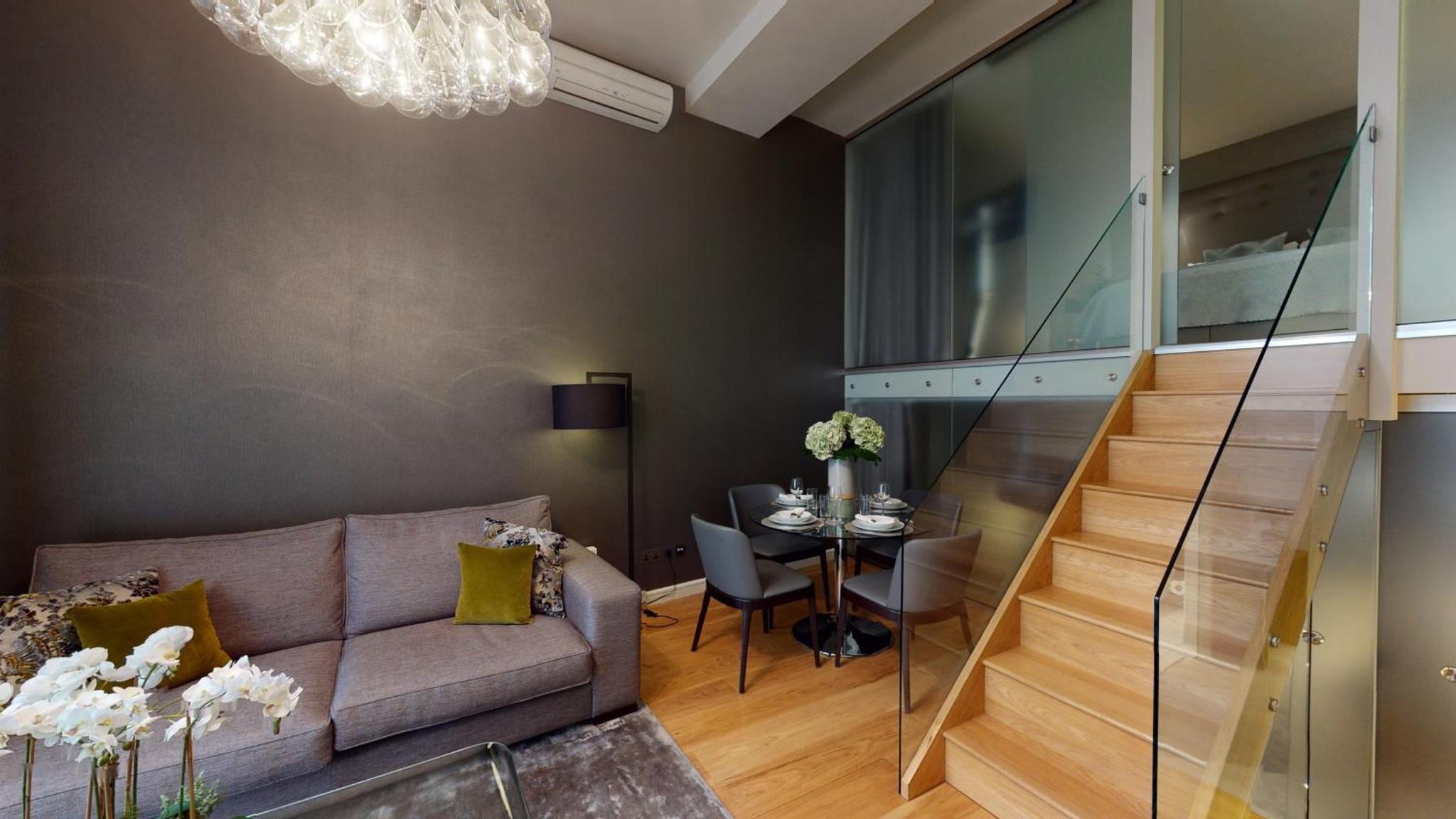 a living room with a couch and a table at The Harrington - Gloucester Road - 1 Harrington Gardens in London