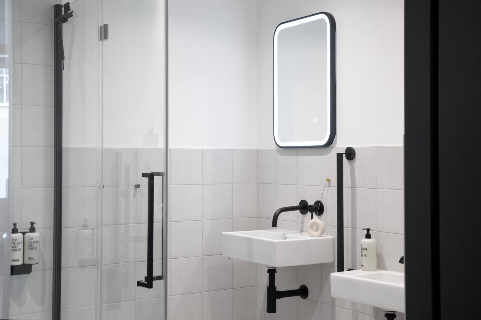 a bathroom with two sinks and a mirror at Bob W London Tower Hill - Studios in London +34 photos