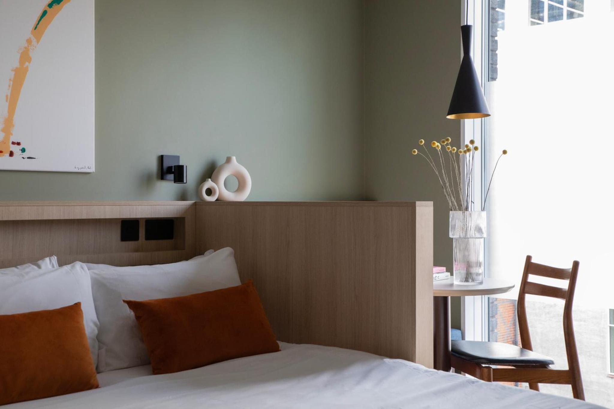 a bedroom with a bed and a table and a chair at Bob W London Tower Hill - Studios in London