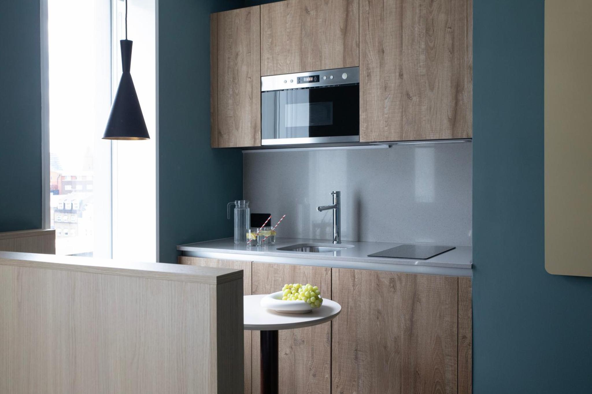 a kitchen with a sink and a microwave above a counter at Bob W London Tower Hill - Studios in London