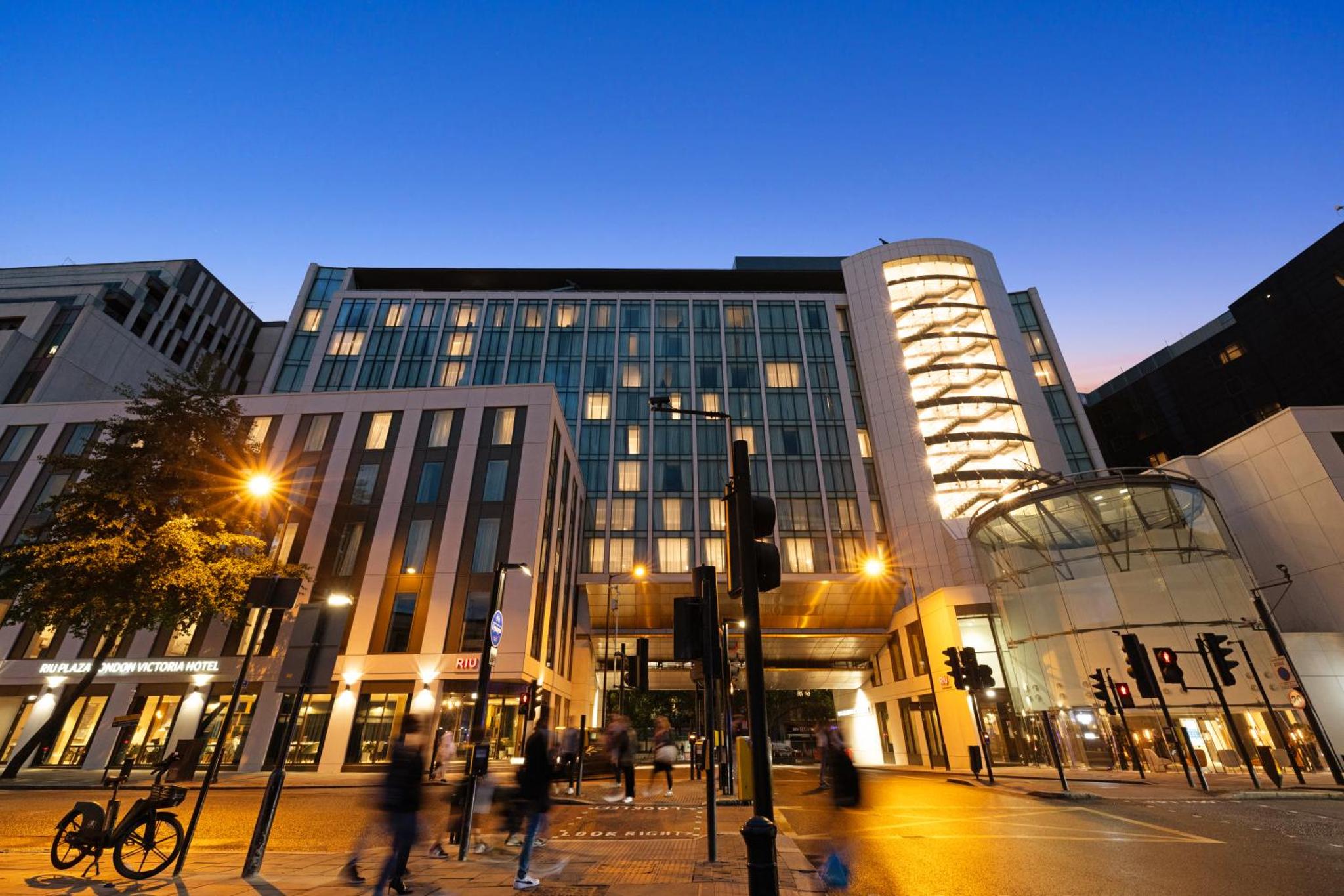 a group of people walking in front of a building at Riu Plaza London Victoria in London