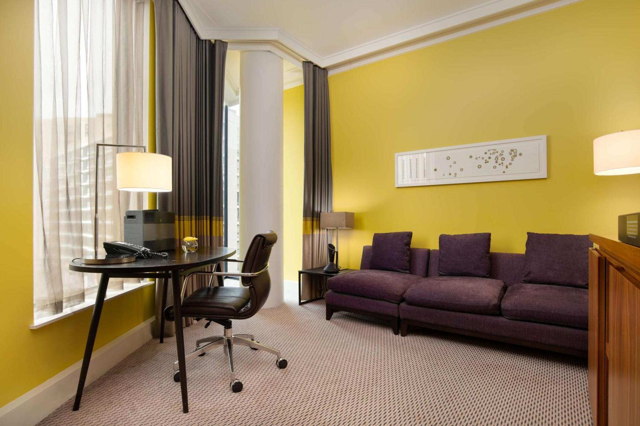 a living room with a couch and a table at Hilton London Wembley in London