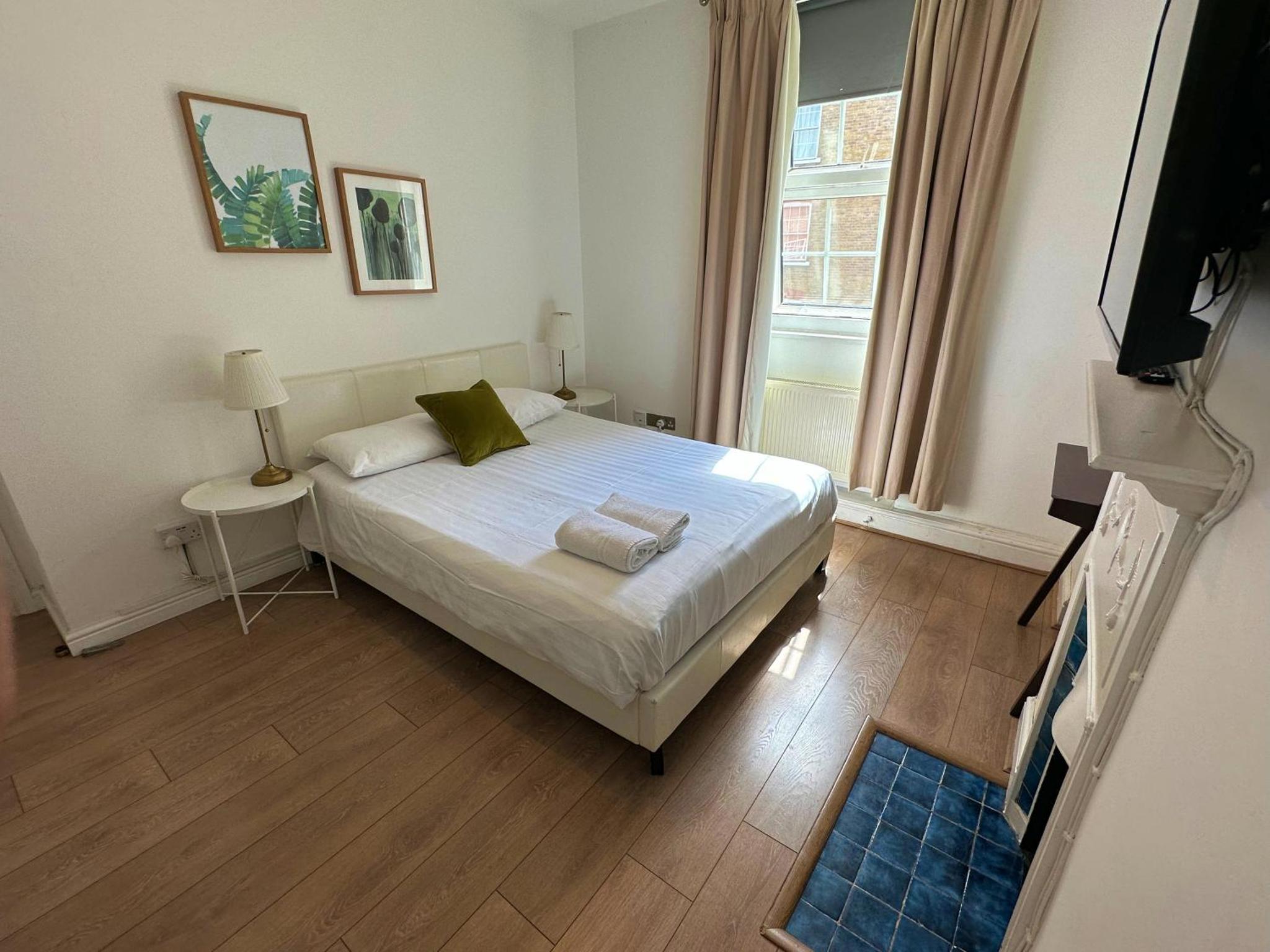 a bedroom with a bed and a television in it at Monopoly in London