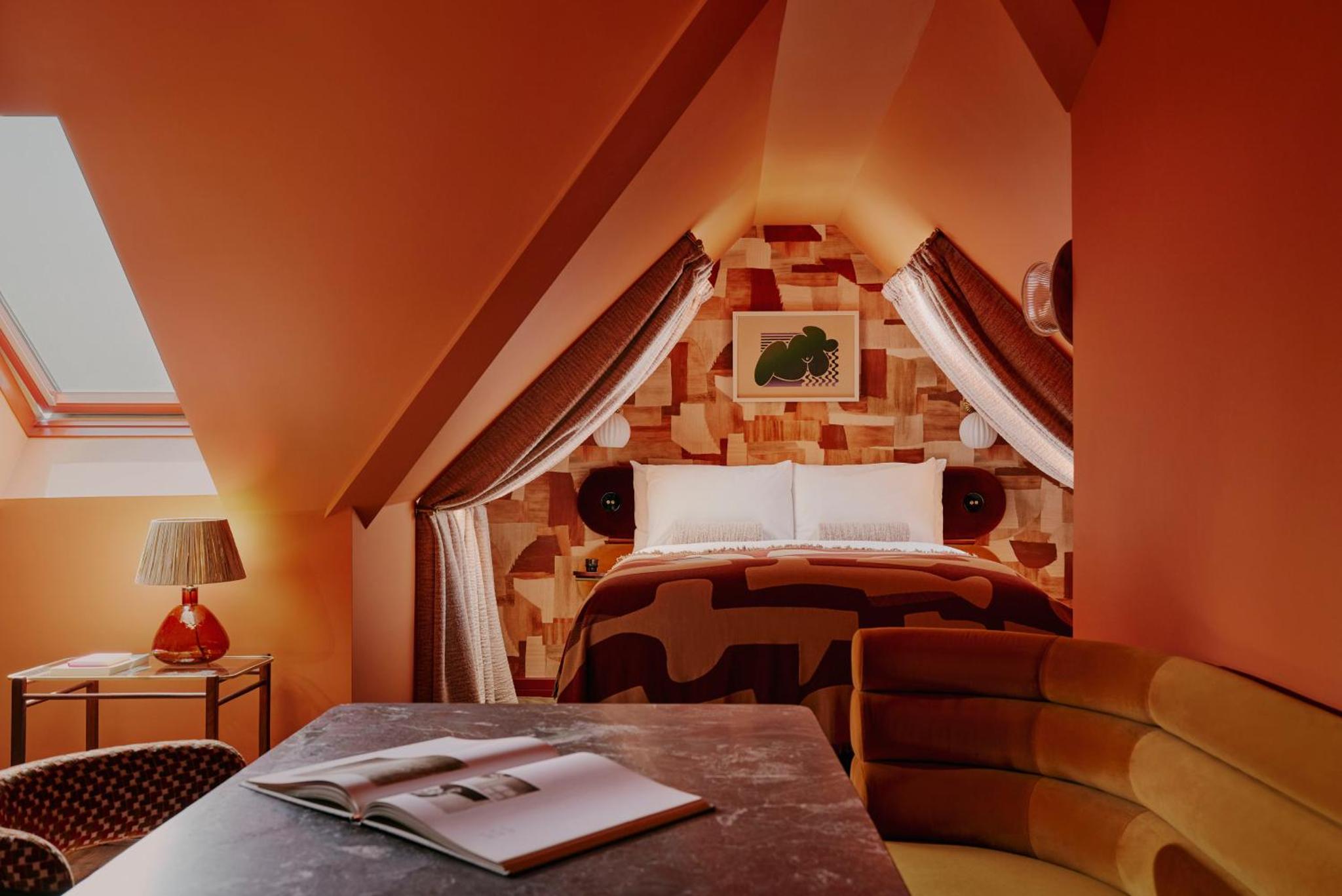 a bedroom with a bed and a couch and a table at Ember Locke Kensington in London