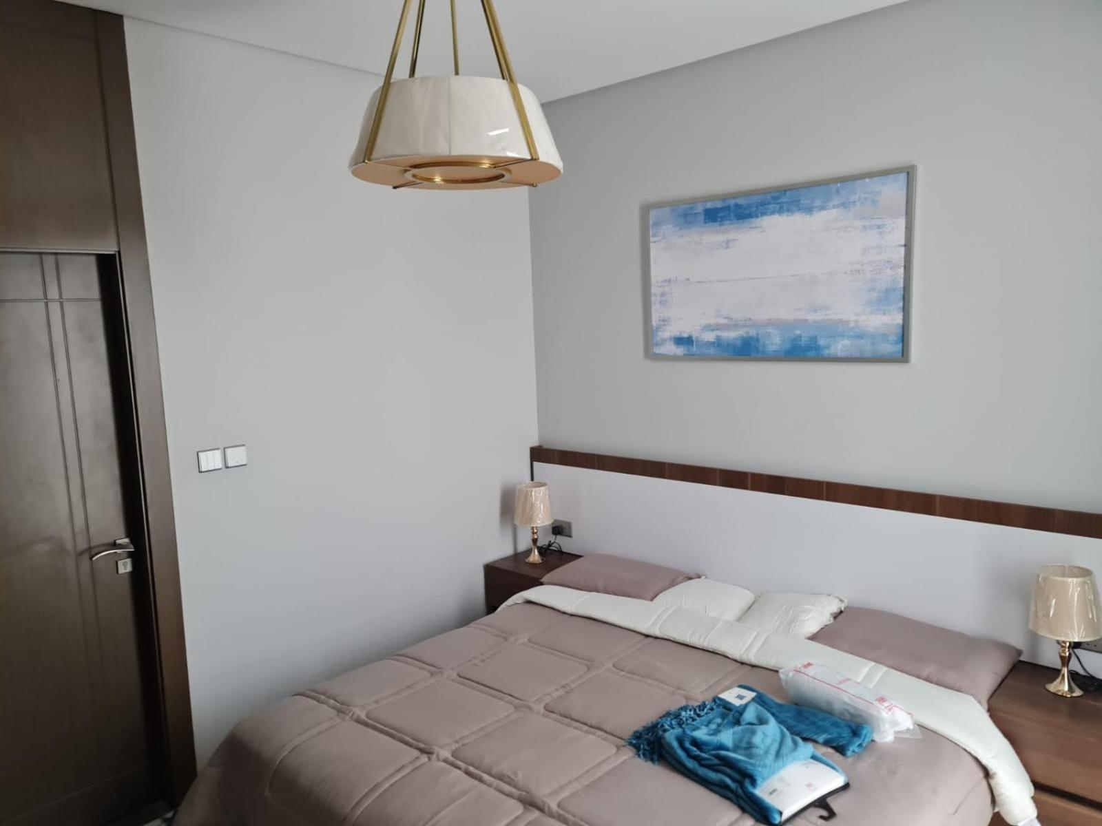 a bedroom with a bed in a white room at شقة مفروشة جديدة مؤثثة بالكامل بالجفير in Manama