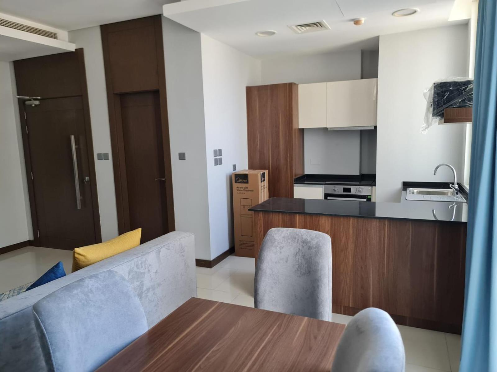 a kitchen and living room with a table and chairs at شقة مفروشة جديدة مؤثثة بالكامل بالجفير in Manama