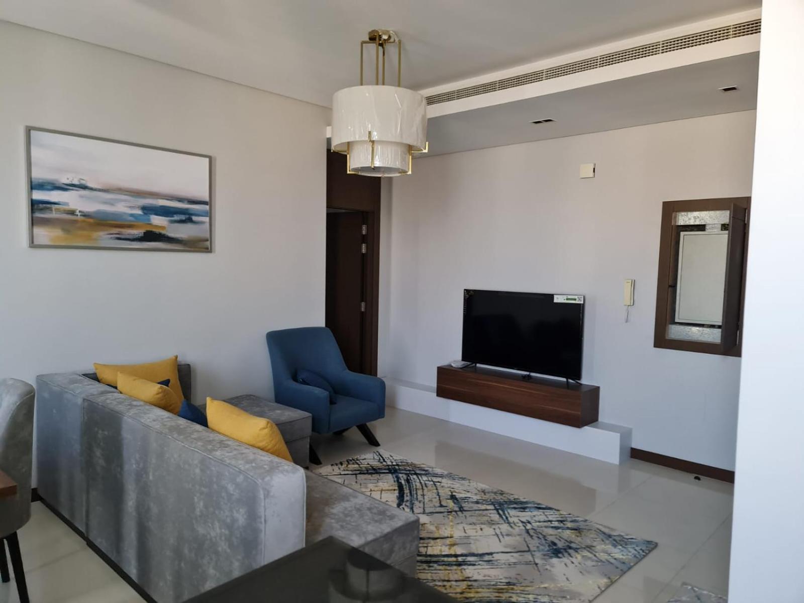 a living room with a couch and a tv at شقة مفروشة جديدة مؤثثة بالكامل بالجفير in Manama +13 photos
