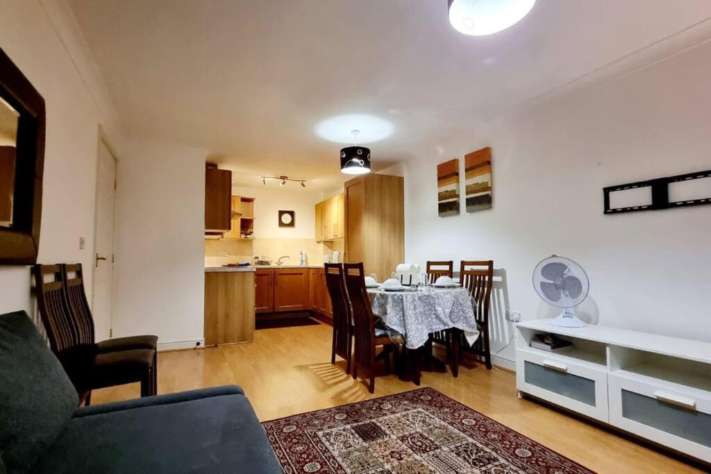 a living room with a table and a kitchen at Entire Home in East London E3 near Bromley By Bow Station in London +13 photos