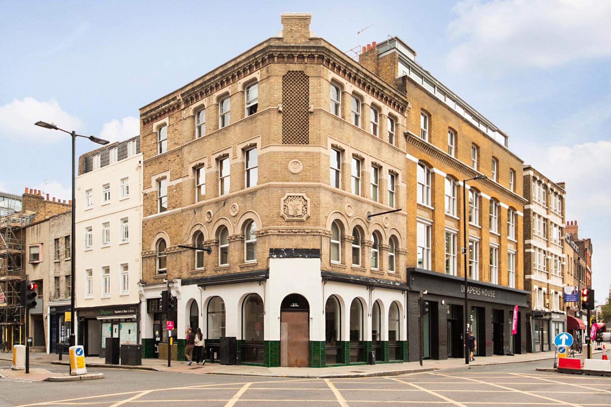 a large brick building on a city street with a street at Luxury Central London Apartment - Farringdon in London