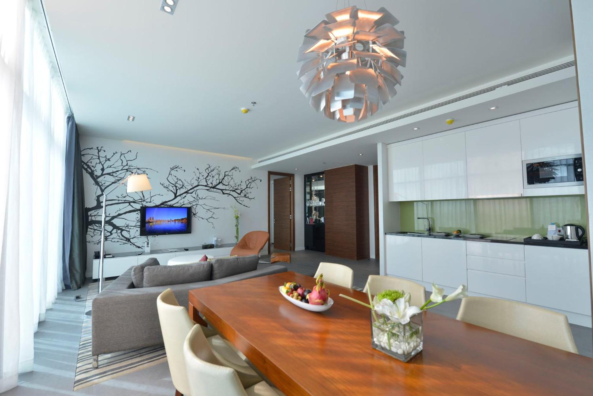 a kitchen and a living room with a wooden table at Ramee Grand Hotel And Spa in Manama +30 photos