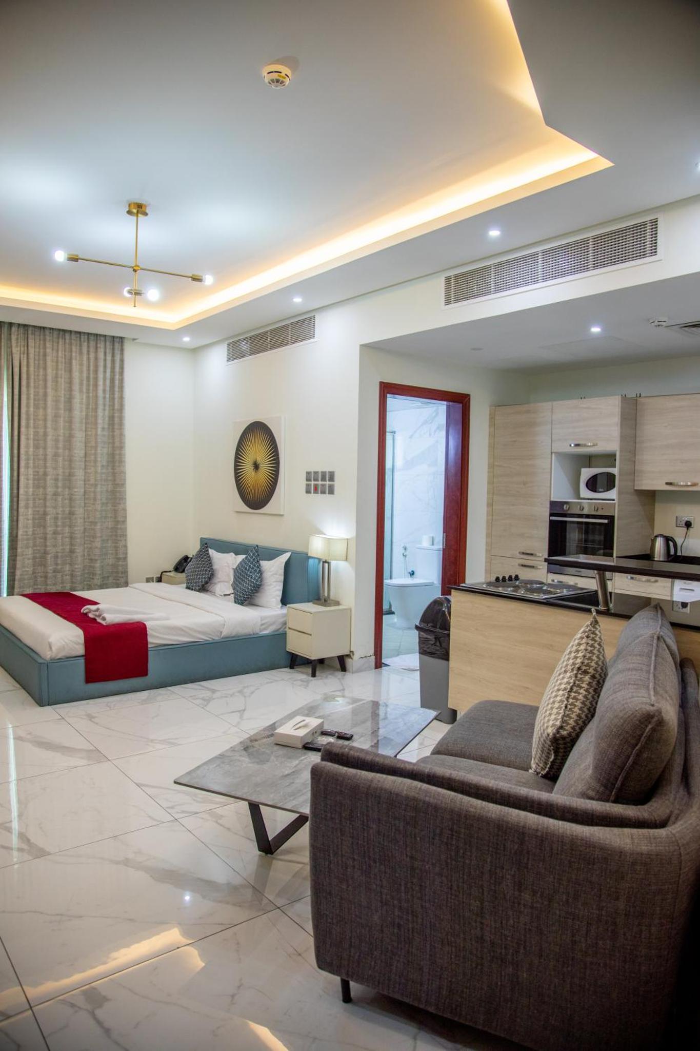 a large living room with a bed and a kitchen at The Apple Residence in Juffair