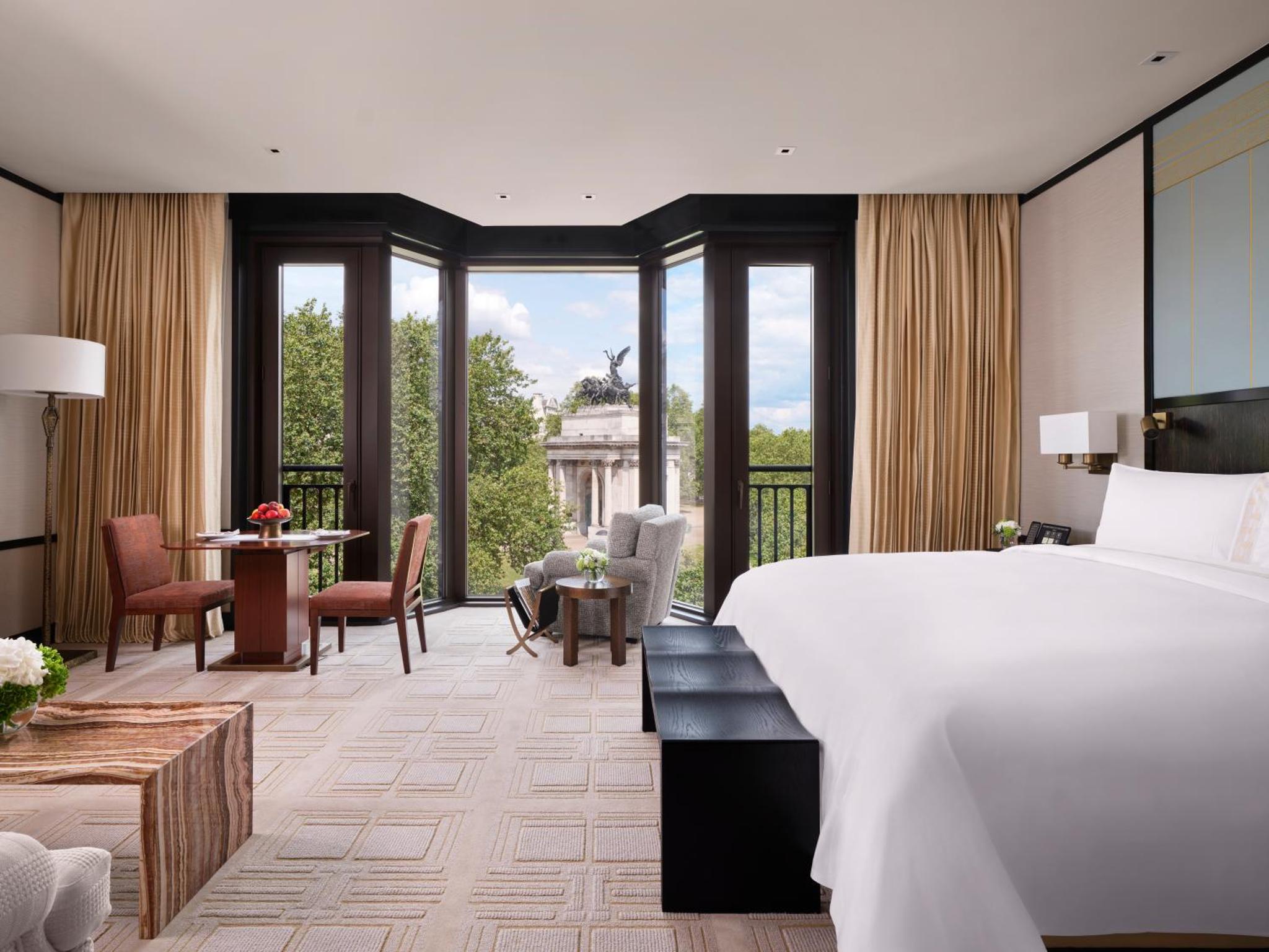 a bedroom with a large bed and a living room at The Peninsula London in London